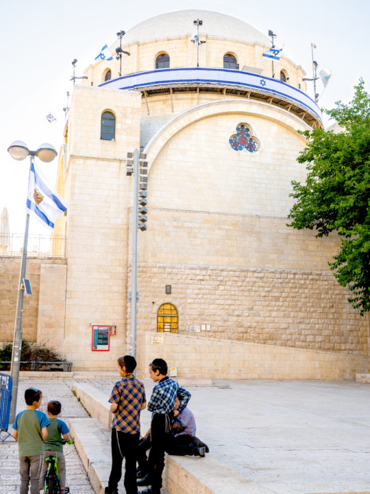 a group of boys standing in front of the Hurva Synagogue